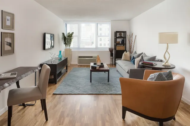 a living room with furniture wooden floor and a lamp