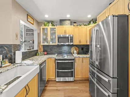 a kitchen with kitchen island granite countertop a refrigerator stove and sink
