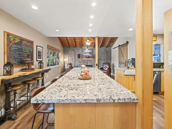 a view of a kitchen with kitchen island granite countertop wooden floor and a counter top space