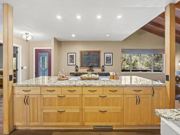 a view of a kitchen with kitchen island white cabinets and stainless steel appliances