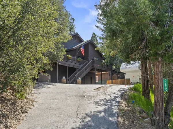 a front view of a house with a tree