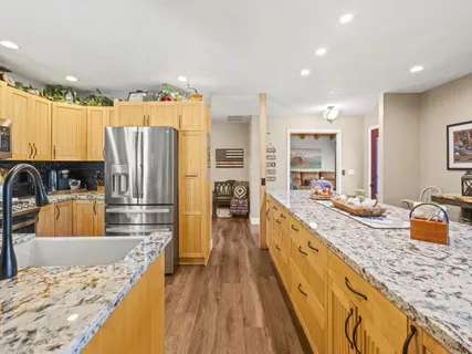 a large kitchen with granite countertop a large counter top appliances and cabinets