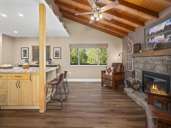 a living room with furniture a fireplace and wooden floor