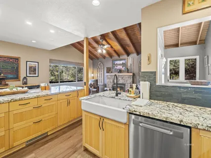 a kitchen with granite countertop a sink and a stove top oven