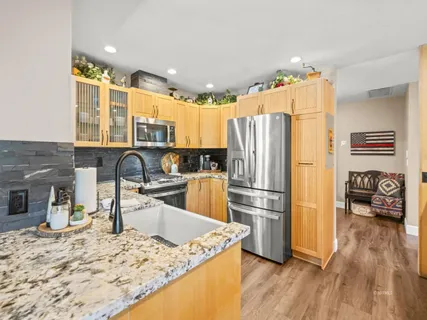 a kitchen with granite countertop a refrigerator and a sink
