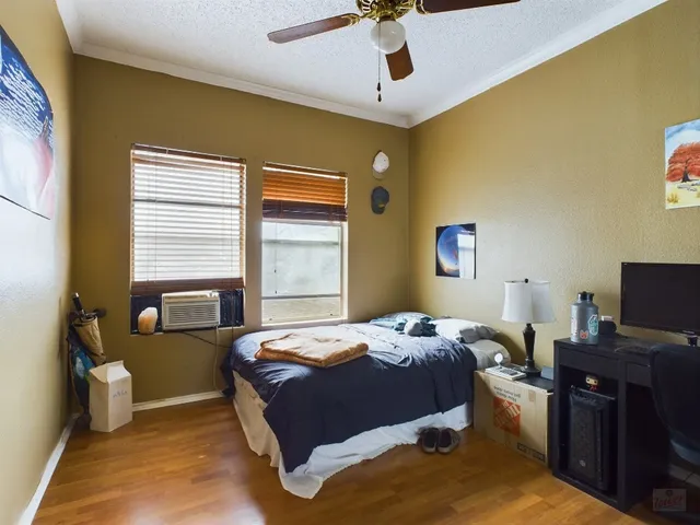 a bedroom with a bed and wooden floor