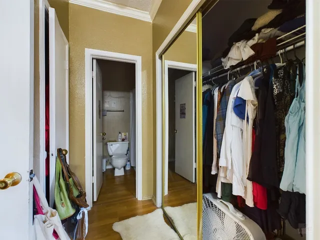 a view of walk in closet with clothes and shoes