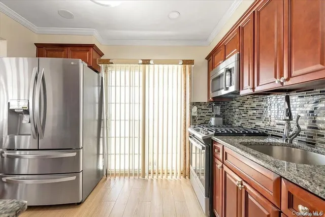 a kitchen with stainless steel appliances granite countertop a refrigerator and a sink