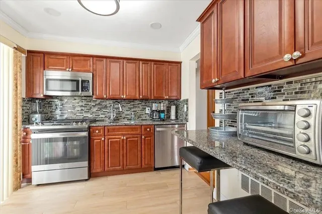 a kitchen with stainless steel appliances granite countertop a stove a sink and a microwave