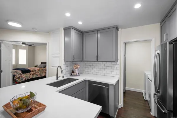 a kitchen that has a sink cabinets and stainless steel appliances