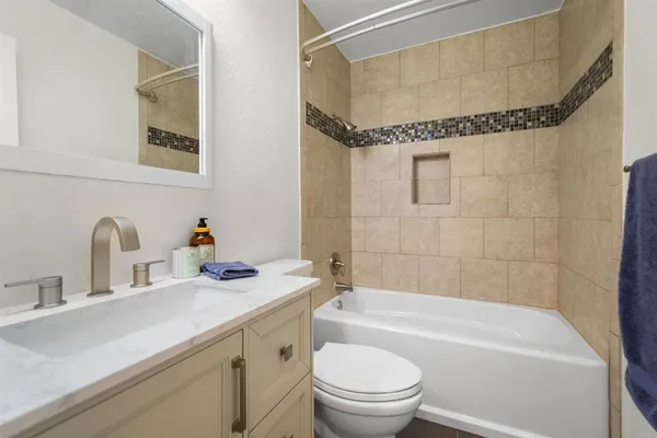 a bathroom with a granite countertop sink a toilet and shower