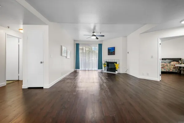 a view of a livingroom with wooden floor a fireplace and window