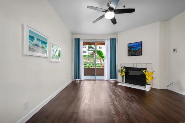 a living room with wooden floor and a fireplace