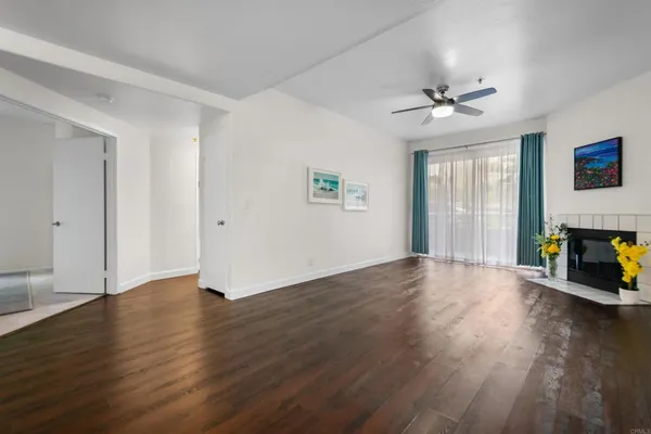 a view of empty room with wooden floor and fireplace