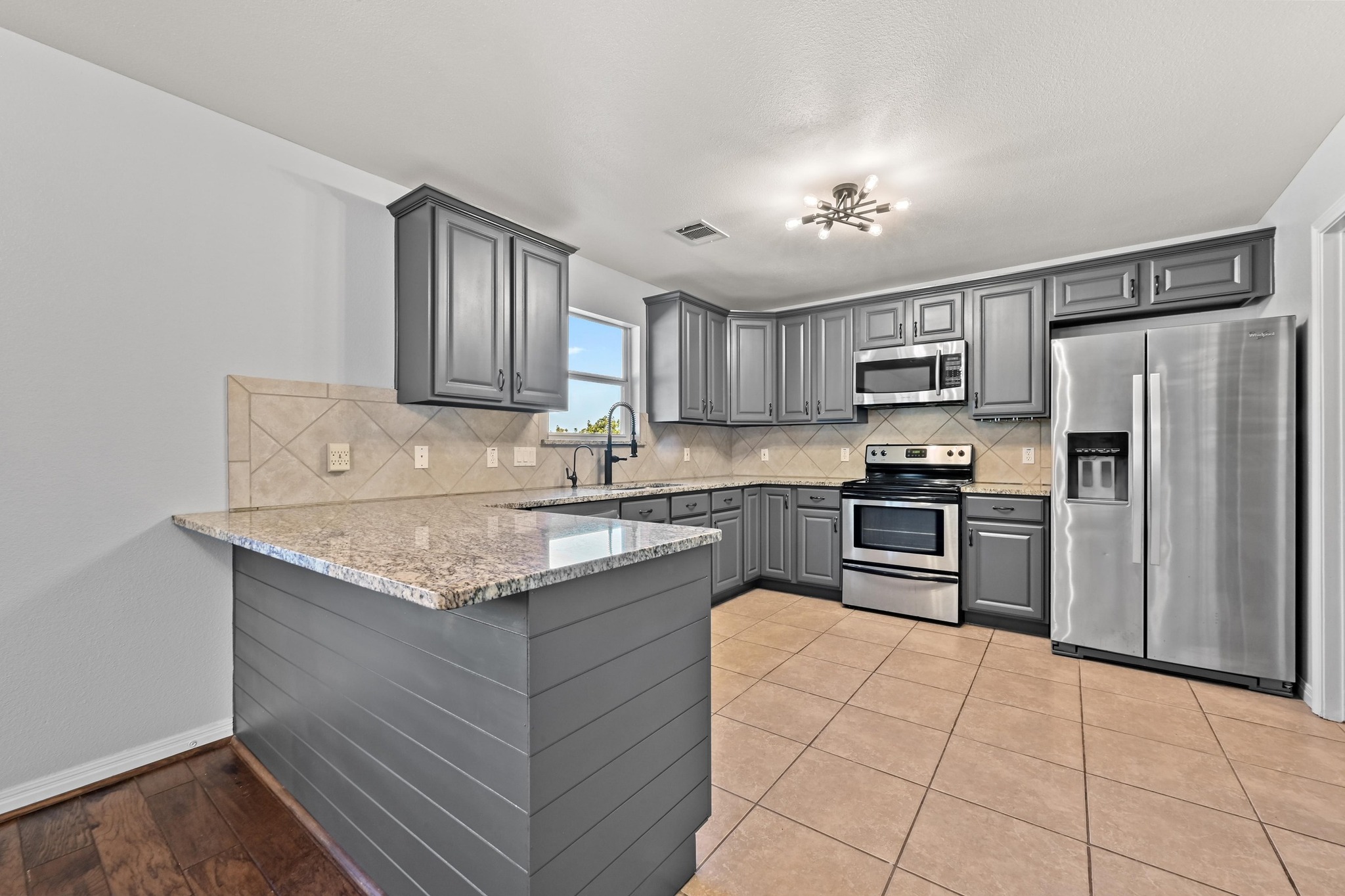 4204 Bob Wire Road Spicewood, TX 78669 - Photo 1 of 25 a kitchen with kitchen island granite countertop a stove sink and refrigerator