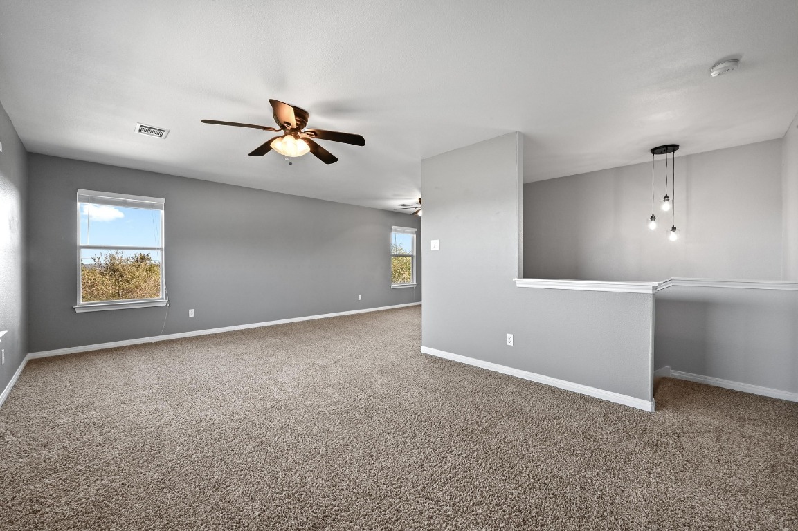 4204 Bob Wire Road Spicewood, TX 78669 - Photo 12 of 24 an empty room with windows and fan
