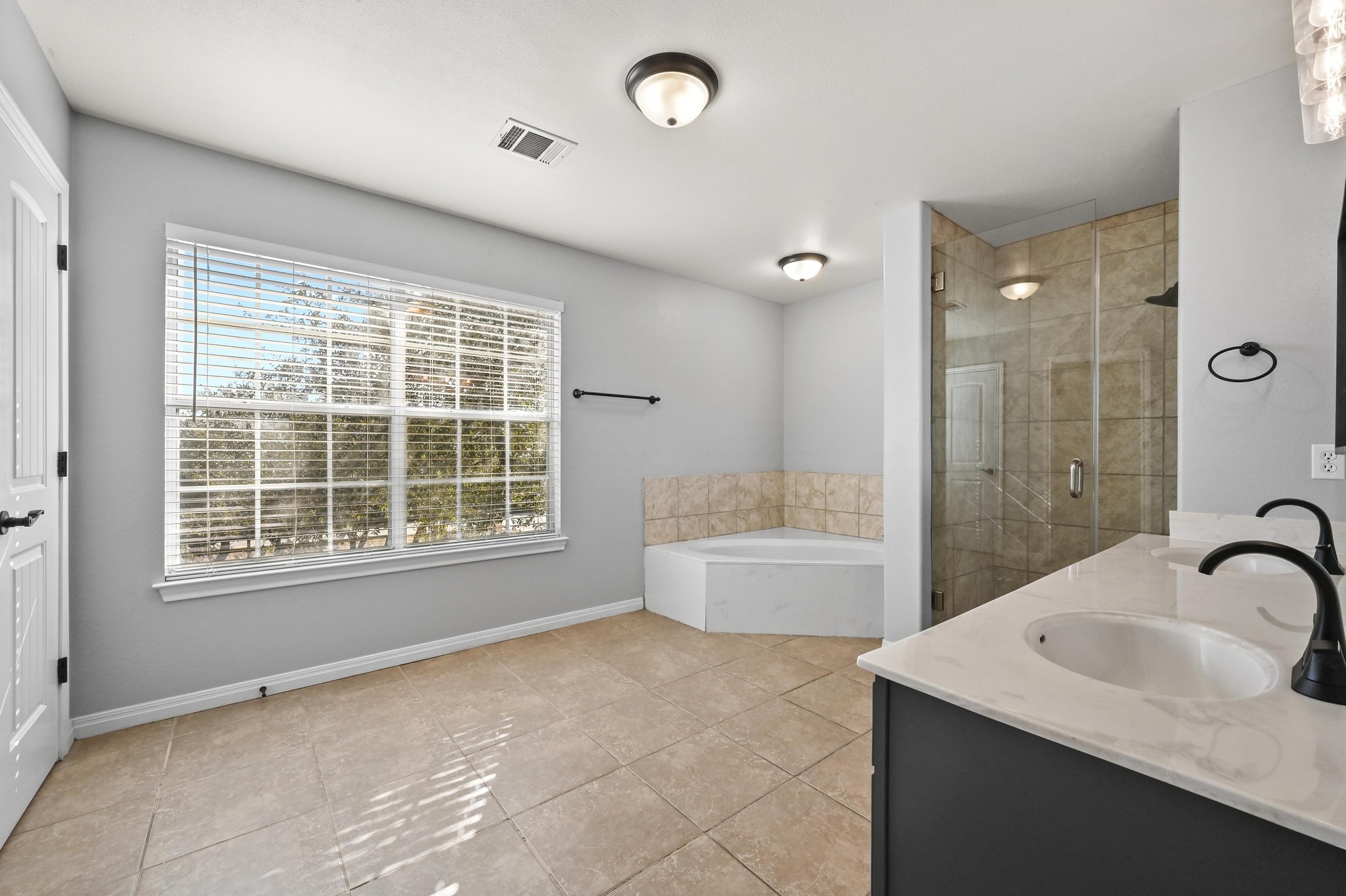 4204 Bob Wire Road Spicewood, TX 78669 - Photo 14 of 25 a bathroom with a granite countertop sink a bathtub and window