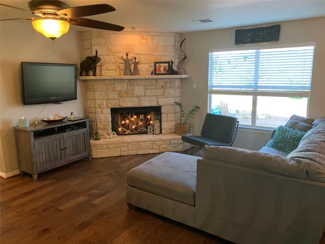 a living room with furniture a flat screen tv and a fireplace