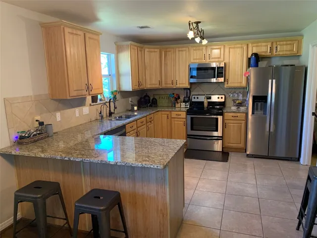 a kitchen with refrigerator and cabinets