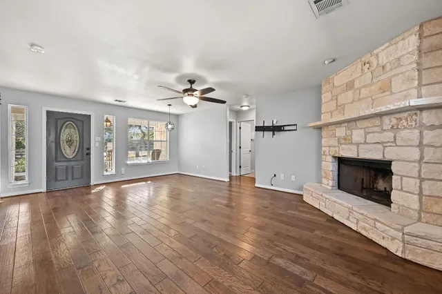 wooden floor fireplace and windows in an empty room