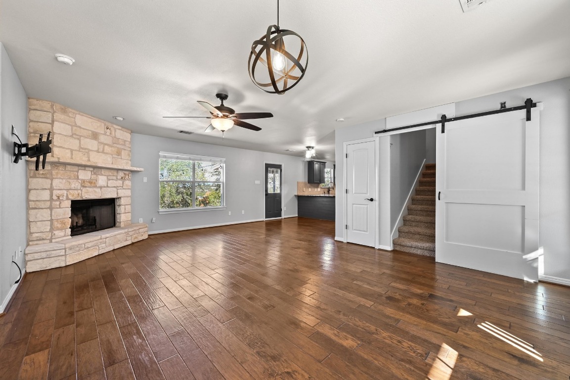 4204 Bob Wire Road Spicewood, TX 78669 - Photo 5 of 24 a view of an empty room with a fireplace and wooden floor