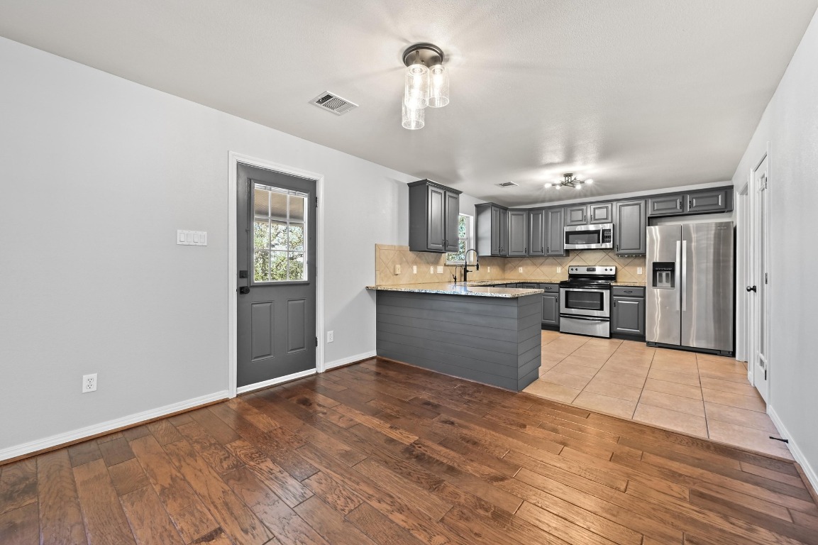 4204 Bob Wire Road Spicewood, TX 78669 - Photo 6 of 24 a large kitchen with cabinets and stainless steel appliances