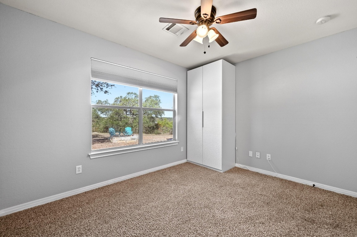 4204 Bob Wire Road Spicewood, TX 78669 - Photo 8 of 24 an empty room with windows and fan