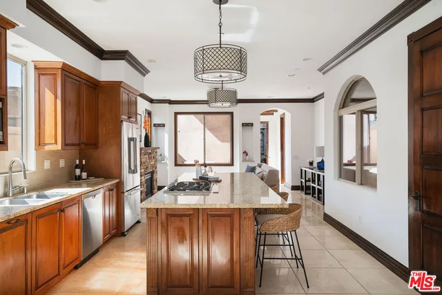 a dining hall with stainless steel appliances granite countertop a stove a sink dishwasher a dining table and chairs with wooden floor