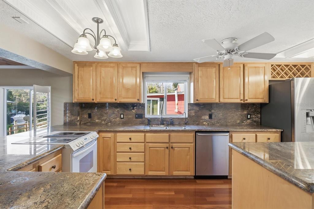 5415 Riverside Drive Yankeetown, FL 34498 - Photo 9 of 45 a kitchen with stainless steel appliances granite countertop a sink a stove cabinets counter space and windows