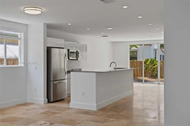 a view of kitchen with furniture and refrigerator