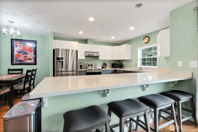a kitchen with kitchen island a table and chairs in it