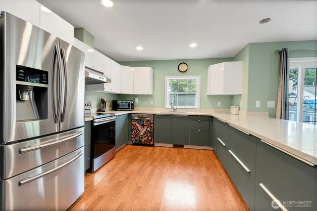 a kitchen with stainless steel appliances a refrigerator sink and microwave