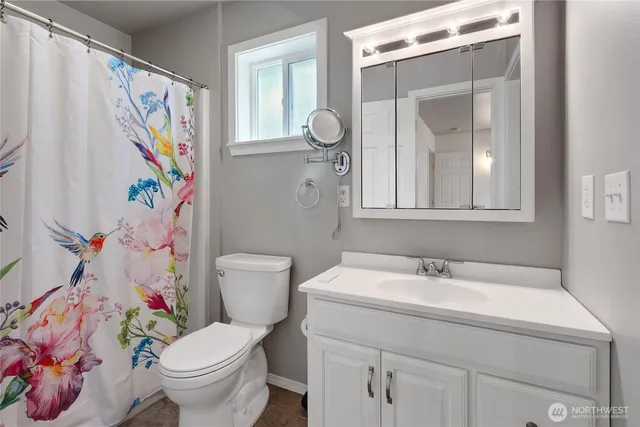 a bathroom with a sink mirror vanity and toilet