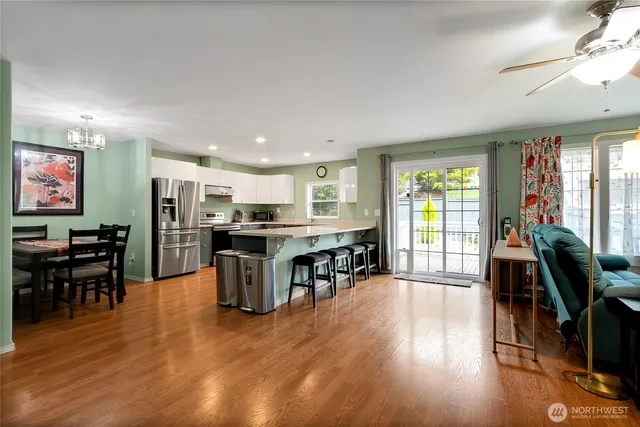 a living room with furniture wooden floor and large windows