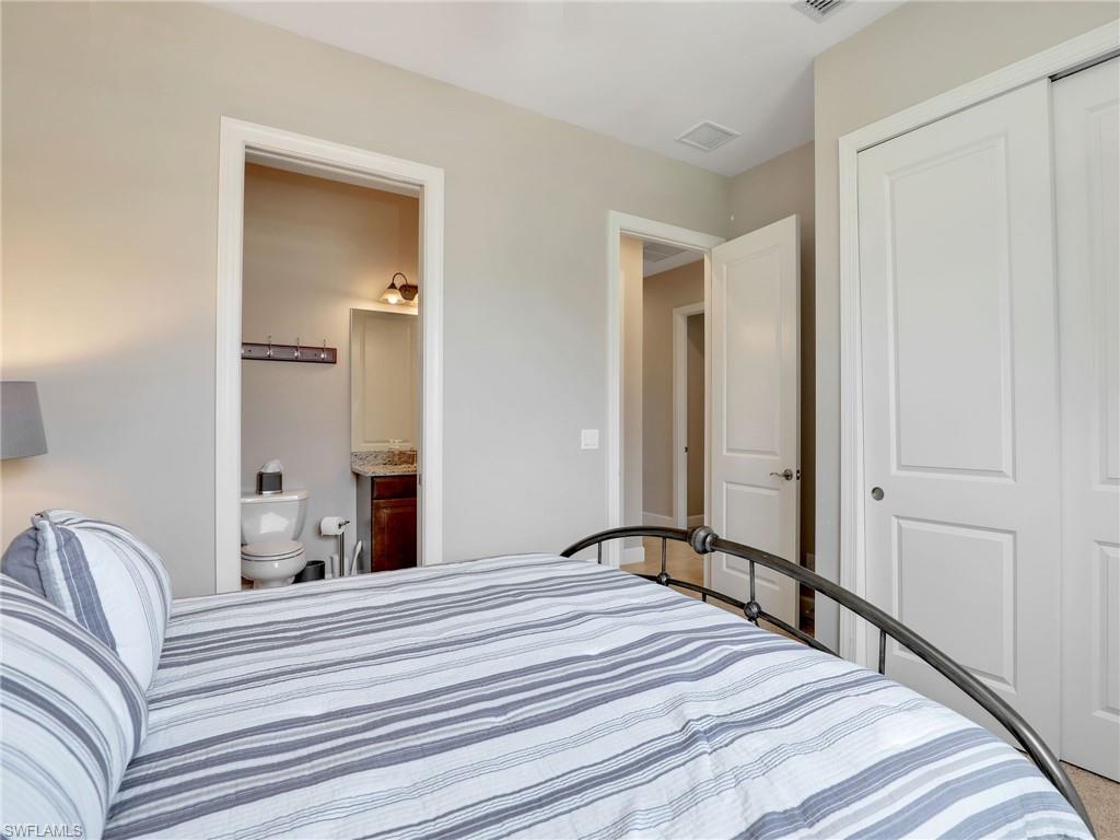 9685 Montelanico Loop, Unit 202 Naples, FL 34119 - Photo 11 of 41 a bedroom with a bed and a mirror