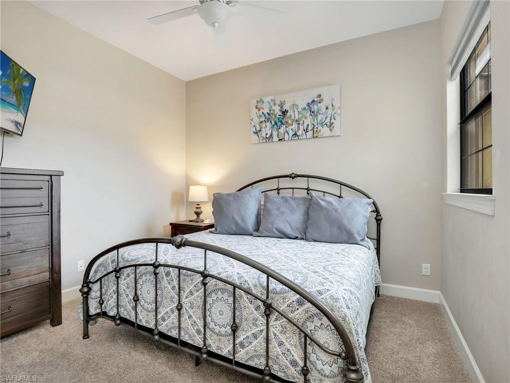 9685 Montelanico Loop, Unit 202 Naples, FL 34119 - Photo 12 of 41 a bedroom with a bed and a painting on the wall