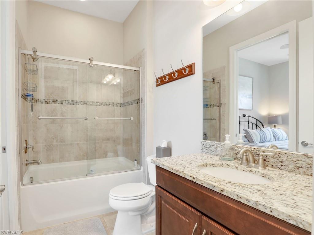 9685 Montelanico Loop, Unit 202 Naples, FL 34119 - Photo 13 of 41 a bathroom with a granite countertop sink toilet mirror and bathtub