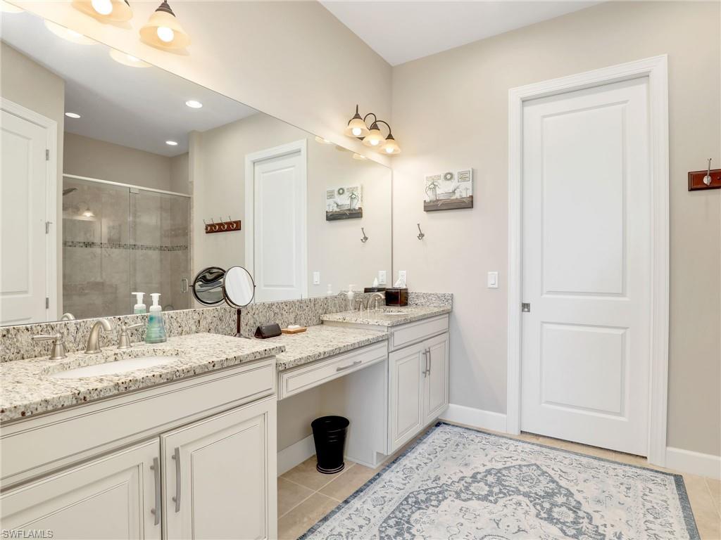 9685 Montelanico Loop, Unit 202 Naples, FL 34119 - Photo 15 of 41 a spacious bathroom with a granite countertop sink and a mirror