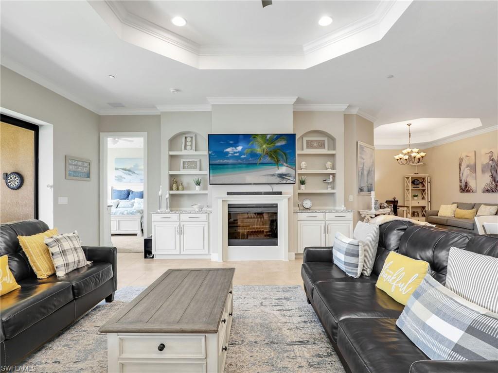 9685 Montelanico Loop, Unit 202 Naples, FL 34119 - Photo 20 of 41 a living room with furniture a flat screen tv and a fireplace