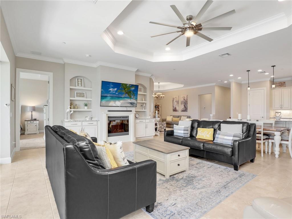 9685 Montelanico Loop, Unit 202 Naples, FL 34119 - Photo 21 of 41 a living room with furniture a fireplace and a ceiling fan