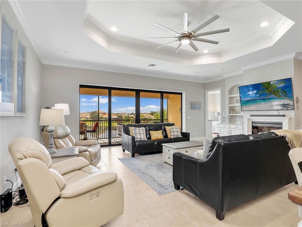9685 Montelanico Loop, Unit 202 Naples, FL 34119 - Photo 23 of 41 a living room with furniture ceiling fan and a large window