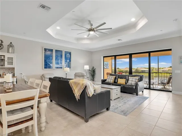 a living room with furniture ceiling fan and a large window