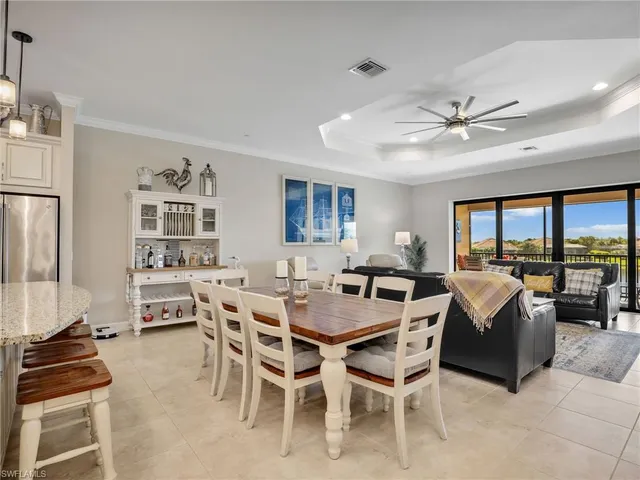 a living room with furniture ceiling fan and a large window