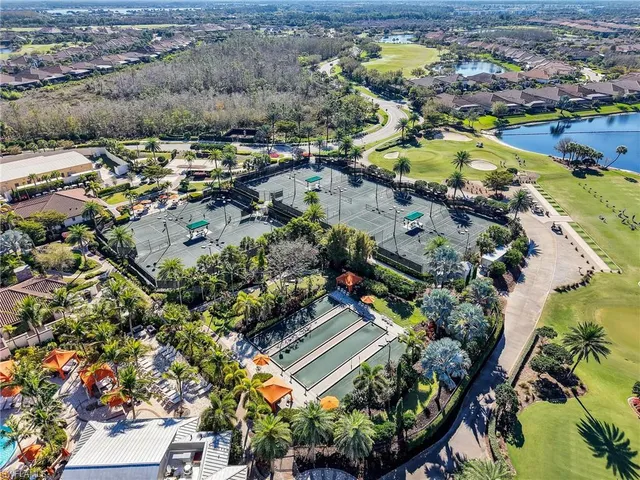 an aerial view of a house with a yard and lake view in back