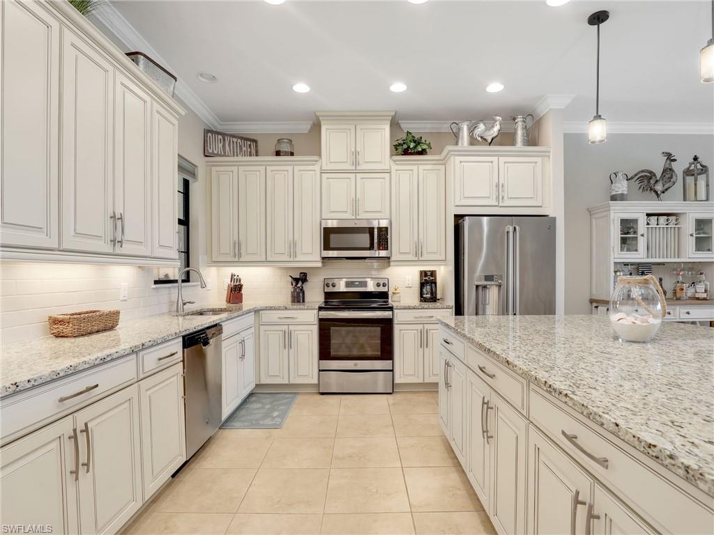 9685 Montelanico Loop, Unit 202 Naples, FL 34119 - Photo 7 of 41 a large kitchen with cabinets stainless steel appliances and a counter space