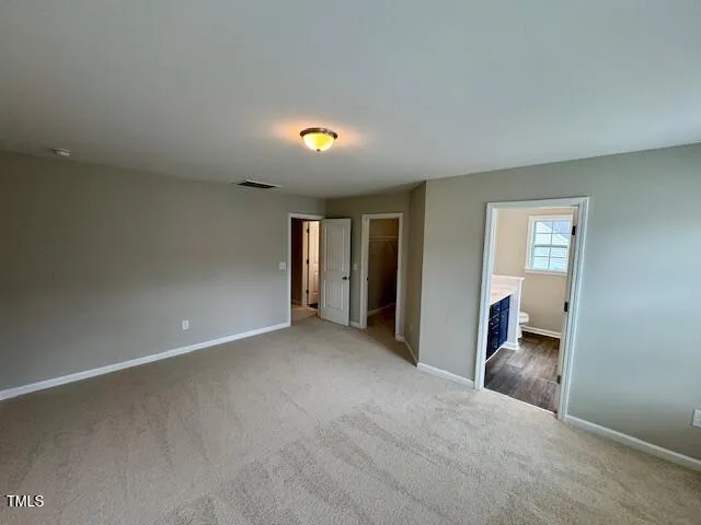 an empty room with windows & cabinet