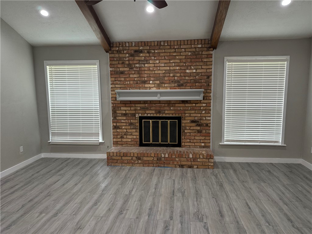 1010 Holt Street College Station, TX 77840 - Photo 3 of 14 an empty room with wooden floor fireplace and windows