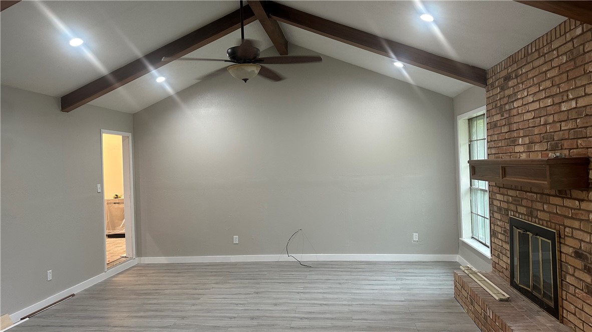 1010 Holt Street College Station, TX 77840 - Photo 6 of 14 an empty room with wooden floor fireplace and windows