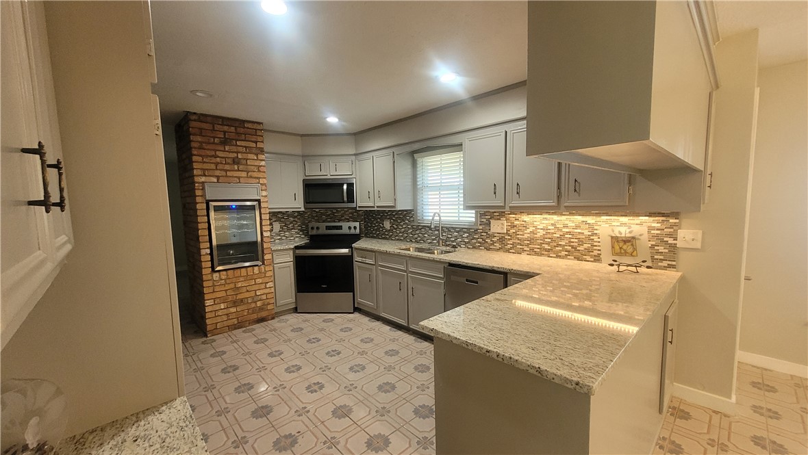 1010 Holt Street College Station, TX 77840 - Photo 9 of 14 a kitchen with a sink a stove top oven and refrigerator