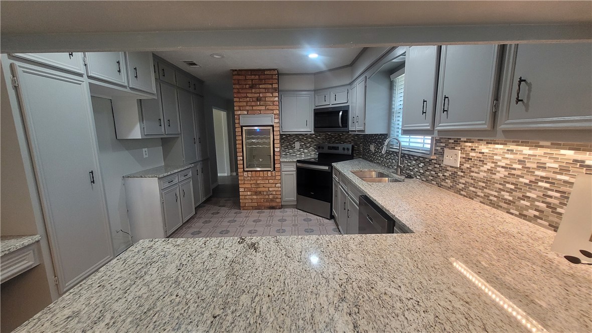 1010 Holt Street College Station, TX 77840 - Photo 10 of 14 a kitchen with stainless steel appliances granite countertop a refrigerator stove and sink